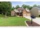 Charming two-story home featuring a stone facade, well-manicured lawn, and a two-car garage at 2430 Hemrick Rd, Cumming, GA 30041
