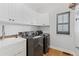 Laundry room features a utility sink, dark appliances, and lots of cabinet space at 2430 Hemrick Rd, Cumming, GA 30041