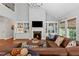 Bright living room with a cozy fireplace, custom bookshelves, and large windows with scenic views at 2430 Hemrick Rd, Cumming, GA 30041