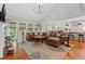 Inviting living room featuring hardwood floors, a comfortable leather sofa, and sunlit windows at 2430 Hemrick Rd, Cumming, GA 30041