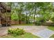 Landscaped backyard with stone paving, mature trees, and wooden fencing, creating a serene outdoor space at 315 Melrose Ave, Decatur, GA 30030