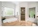 Bright bathroom featuring a soaking tub under a window and a glass-enclosed shower at 315 Melrose Ave, Decatur, GA 30030