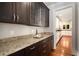 View of butler's pantry featuring granite countertops and dark wood cabinetry at 315 Melrose Ave, Decatur, GA 30030