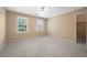 A carpeted bedroom featuring light colored walls, ceiling fan, and two sunny windows at 3741 Bays Ferry Way, Marietta, GA 30062
