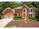Attractive brick home featuring manicured landscaping and a two-car garage with large front windows at 3741 Bays Ferry Way, Marietta, GA 30062