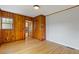 Bedroom features knotty pine accent wall and hardwood floors with lots of light at 1312 Milstead Ave, Conyers, GA 30012