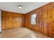Bedroom with knotty pine walls, hardwood floors and a window at 1312 Milstead Ave, Conyers, GA 30012