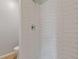 Shower in a modern bathroom with white honeycomb tile and tiled floor at 1312 Milstead Ave, Conyers, GA 30012