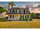 Charming two-story home with black shutters, a covered porch, landscaped yard, and fresh green grass at 1700 Conductor Ln, Conyers, GA 30013
