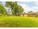Large grassy backyard showcasing the home's exterior brickwork and ample space for outdoor activities at 2696 Eldorado Pl, Snellville, GA 30078