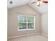 Bedroom with a large window and view of lush greenery and neutral carpet at 6107 Malloway Ct # B-6107, Cumming, GA 30041