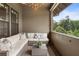 Covered balcony with a cozy outdoor seating area and a peaceful view of surrounding trees at 6613 Encore Blvd, Atlanta, GA 30328