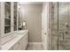 Neutrally painted bathroom with gray tiled shower, display cabinet and white vanity and fixtures at 6613 Encore Blvd, Atlanta, GA 30328