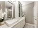 Stylish bathroom with double sinks, a glass-enclosed shower, and a decorative display cabinet at 6613 Encore Blvd, Atlanta, GA 30328