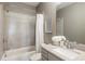 Bright bathroom features a shower-tub combo, neutral tile, and a white vanity with a light countertop at 6613 Encore Blvd, Atlanta, GA 30328