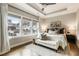 Sunlit bedroom with a tray ceiling, light gray walls, and a large window overlooking rooftops at 6613 Encore Blvd, Atlanta, GA 30328