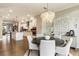 Bright open-concept dining area features a modern chandelier and leads into a spacious kitchen with stainless steel appliances at 6613 Encore Blvd, Atlanta, GA 30328