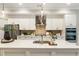 Spacious kitchen with island, stainless appliances, white cabinets, modern pendant lighting and seamless integration to living area at 6613 Encore Blvd, Atlanta, GA 30328