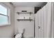 A clean and bright bathroom with a tiled shower, storage shelving, and modern toilet at 7250 Hunters Branch Dr, Atlanta, GA 30328