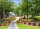 A long driveway leads to a charming blue two-story home nestled in a lush, wooded landscape at 7250 Hunters Branch Dr, Atlanta, GA 30328
