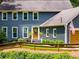 Close-up view of a charming blue two-story home with a welcoming front door and manicured landscaping at 7250 Hunters Branch Dr, Atlanta, GA 30328