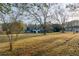 Expansive backyard featuring a blue home with a white porch and ample lawn space surrounded by trees at 110 Fox Meadow Dr, Covington, GA 30016