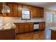 Well-lit kitchen featuring wood cabinets, granite countertops, and hardwood floors at 110 Fox Meadow Dr, Covington, GA 30016