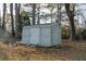 A rustic shed is nestled among tall trees and fallen leaves, offering ample storage space in the backyard at 110 Fox Meadow Dr, Covington, GA 30016