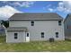 The back exterior features gray siding, a well-maintained lawn, and access door at 117 Oliver Dr, Locust Grove, GA 30248