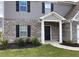 This home features brick accents, dark shutters, a well-manicured lawn, and a covered entryway at 117 Oliver Dr, Locust Grove, GA 30248
