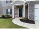 Inviting front exterior features brick accents, well-manicured lawn, covered entryway, and walkway to the front door at 117 Oliver Dr, Locust Grove, GA 30248