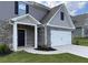 This home's exterior features brick and stone accents, an attached garage, manicured lawn, and a covered entryway at 117 Oliver Dr, Locust Grove, GA 30248