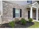 This home features brick accents, dark shutters, a well-manicured lawn, and a covered entryway at 117 Oliver Dr, Locust Grove, GA 30248