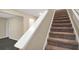 Carpeted staircase with white handrail, connecting the home's multiple levels at 117 Oliver Dr, Locust Grove, GA 30248