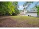 Lush backyard featuring mature trees, a detached garage, and a grassy lawn at 1382 Elizabeth Ln, Atlanta, GA 30344