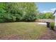 Spacious backyard with lush greenery, mature trees, and a concrete patio area at 1382 Elizabeth Ln, Atlanta, GA 30344
