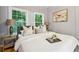 Bright bedroom features two windows, a comfortable bed, stylish lamps, and an elegant painting at 1382 Elizabeth Ln, Atlanta, GA 30344