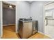 Spacious laundry room featuring stainless steel washer and dryer, connecting to bedroom and kitchen at 1382 Elizabeth Ln, Atlanta, GA 30344