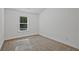 A sunlit bedroom with neutral carpet and a window overlooking trees at 2235 Mulsanne Dr, Lithonia, GA 30058