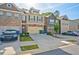 Exterior view of townhomes featuring attached garages, manicured lawns, and variety of exterior materials at 2235 Mulsanne Dr, Lithonia, GA 30058
