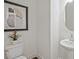 Neutral powder room features a pedestal sink, decorative mirror, and modern toilet at 2235 Mulsanne Dr, Lithonia, GA 30058