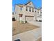 Two-story townhouse with a two-car garage, front door, and a well-manicured lawn at 2240 Mulsanne Dr, Lithonia, GA 30058