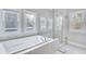Bright bathroom with a separate tub and glass shower, enhanced by natural light from the windows at 2304 Isla Run Run, Woodstock, GA 30188