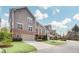 Two-story townhouse with brick accents, garage, manicured lawn, and a private upper-level deck at 2304 Isla Run Run, Woodstock, GA 30188