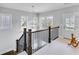 Hallway with dark wood banister and view of the stairs and a white door at the end at 2304 Isla Run Run, Woodstock, GA 30188