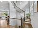 Elegant staircase featuring wooden steps and railings, complemented by natural light from nearby windows at 2304 Isla Run Run, Woodstock, GA 30188