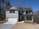 Two-story home featuring a covered porch, attached garage, and neutral siding on a sunny day at 250 Shawnee Trl, Dallas, GA 30157