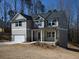 Charming two-story home features a covered porch, attached garage, and neutral siding, creating an inviting curb appeal at 250 Shawnee Trl, Dallas, GA 30157