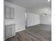 Open-concept living space with gray flooring flows into the kitchen featuring granite countertops and gray cabinets at 250 Shawnee Trl, Dallas, GA 30157
