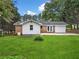 Backyard view of the home with a freshly cut lawn, a patio, and a white-sided addition at 414 Landers Sw Dr, Mableton, GA 30126